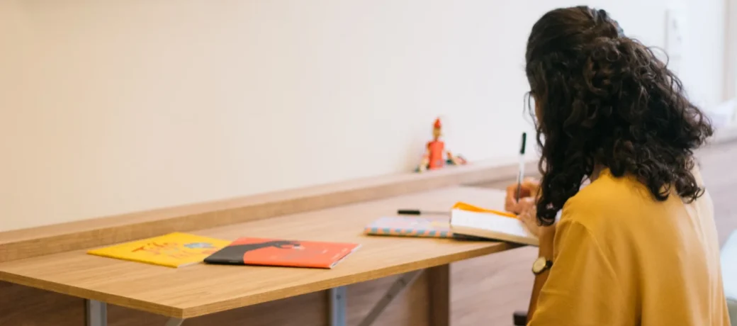 Beatriz à mesa da clínica, com livros infantis